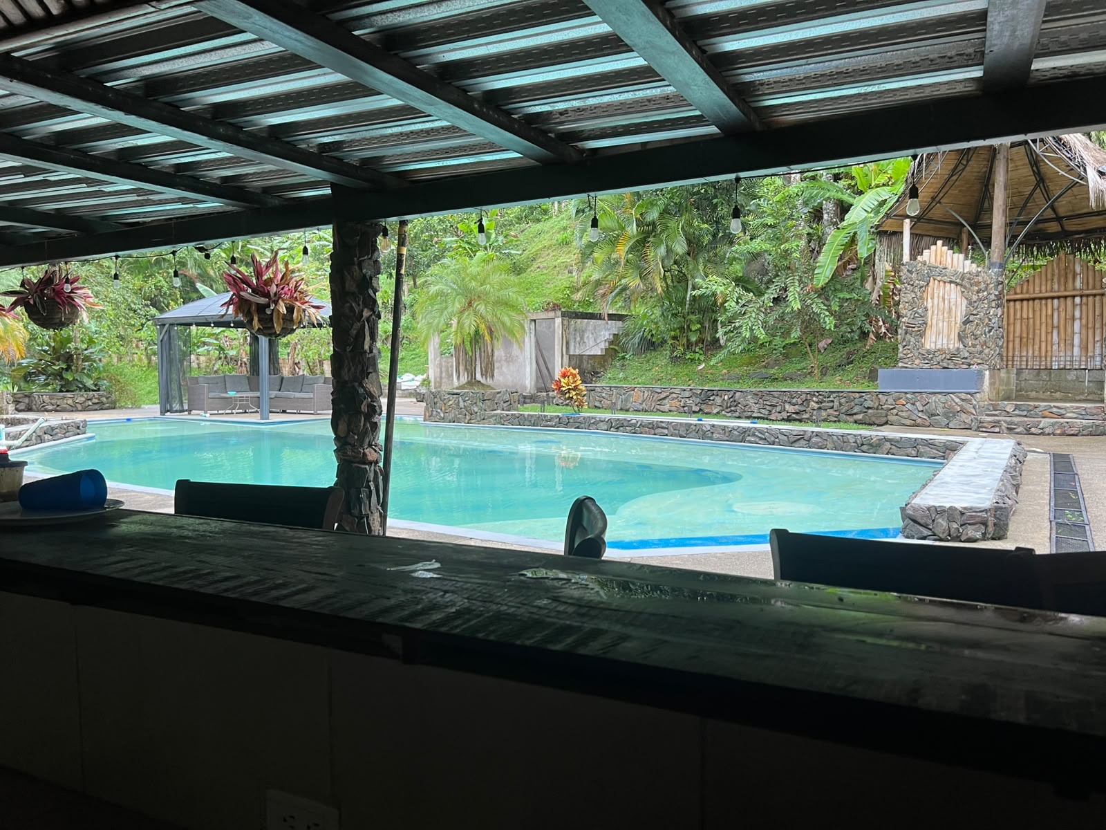 The pool — full, stone-walled, wrapped in jungle